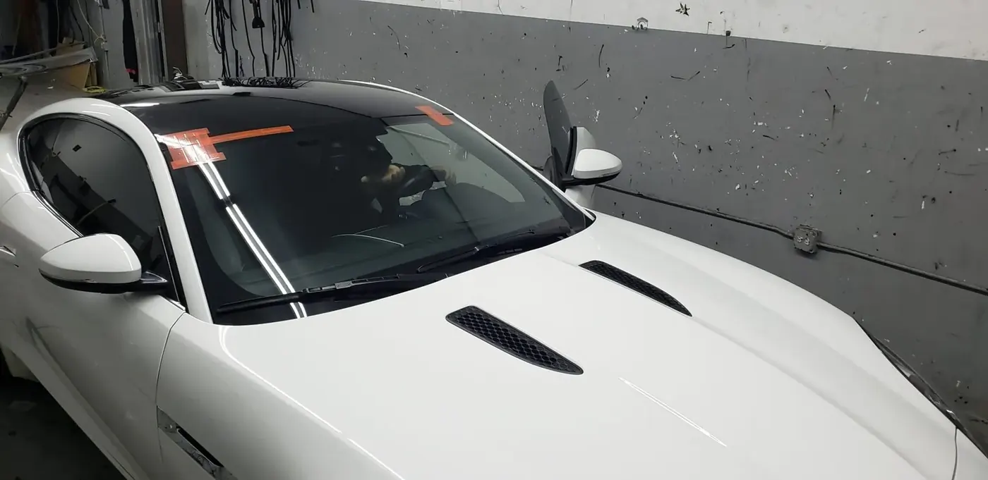 Windshield service on a white sedan