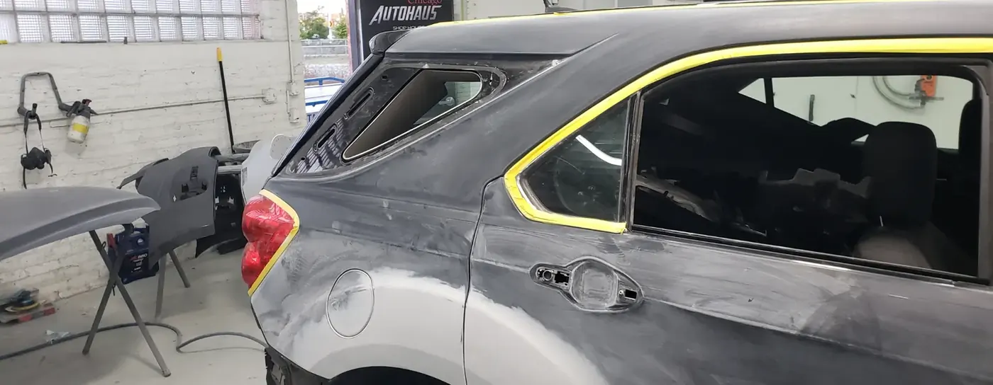 Vehicle being prepped for scratch and dent repair with panels removed in the shop